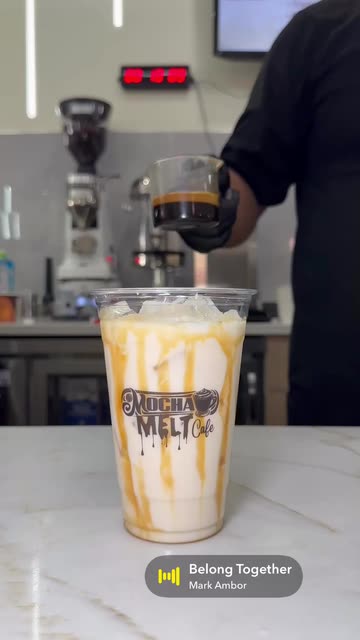 Iced Tiramisu Latte in a Mocha Melt Cafe cup as espresso is poured over it